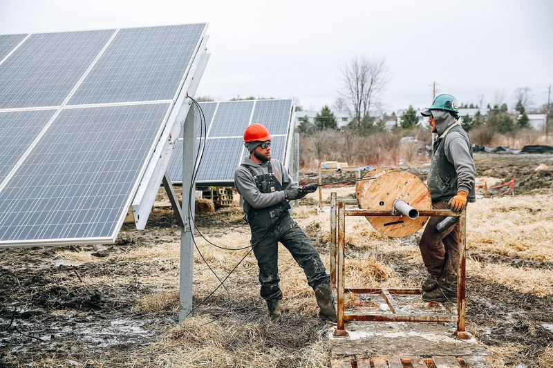 Solar installers working on a rooftop photovoltaic array